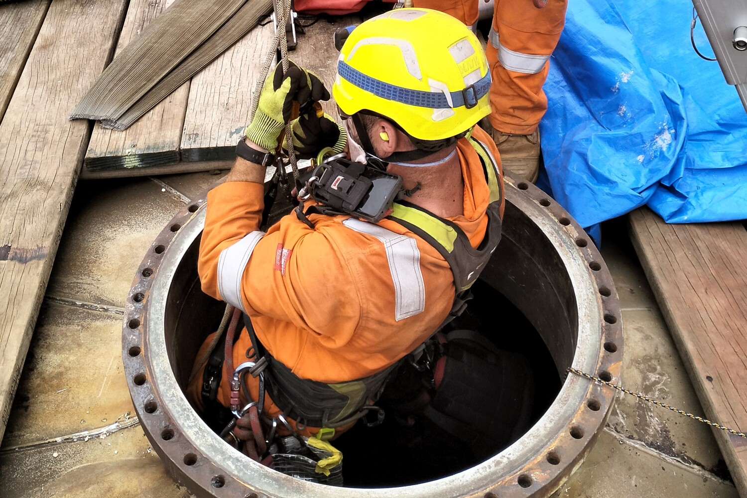 Rope access technician being lowered into a purifier vessel to conduct inspections,